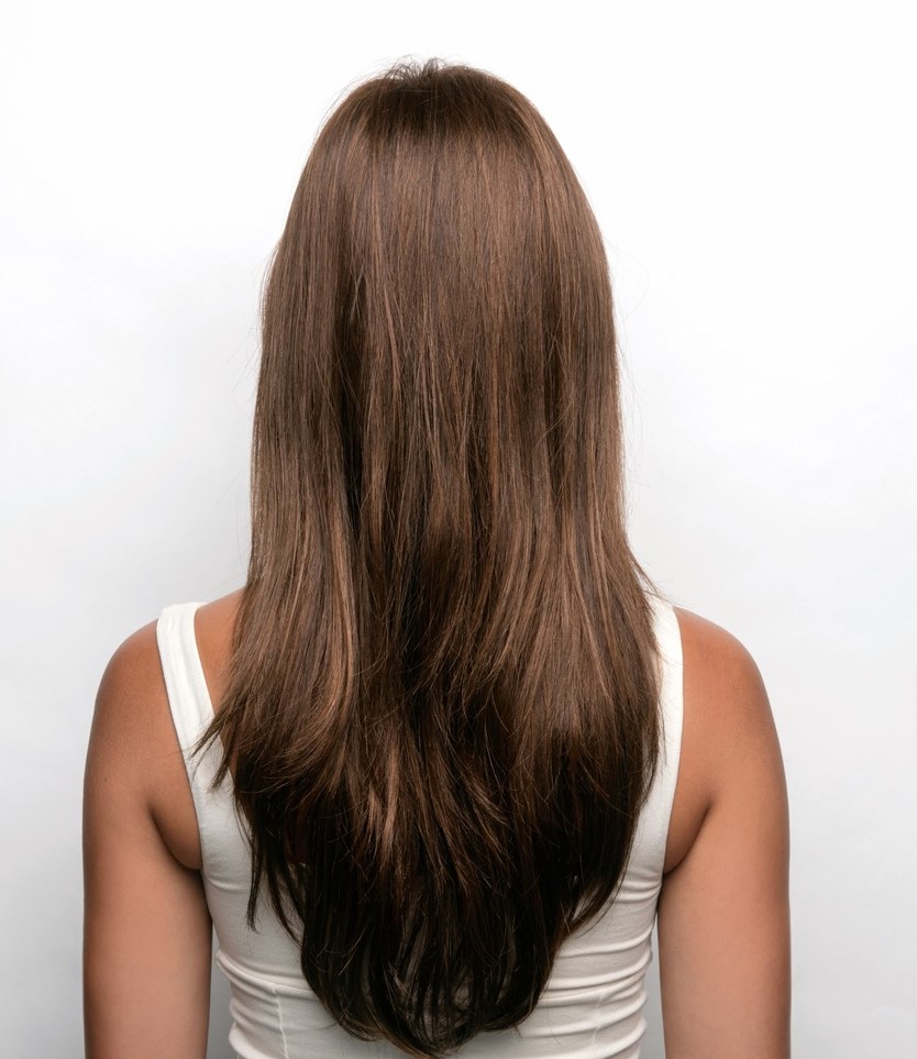 Back profile of woman wearing long and textured wig.