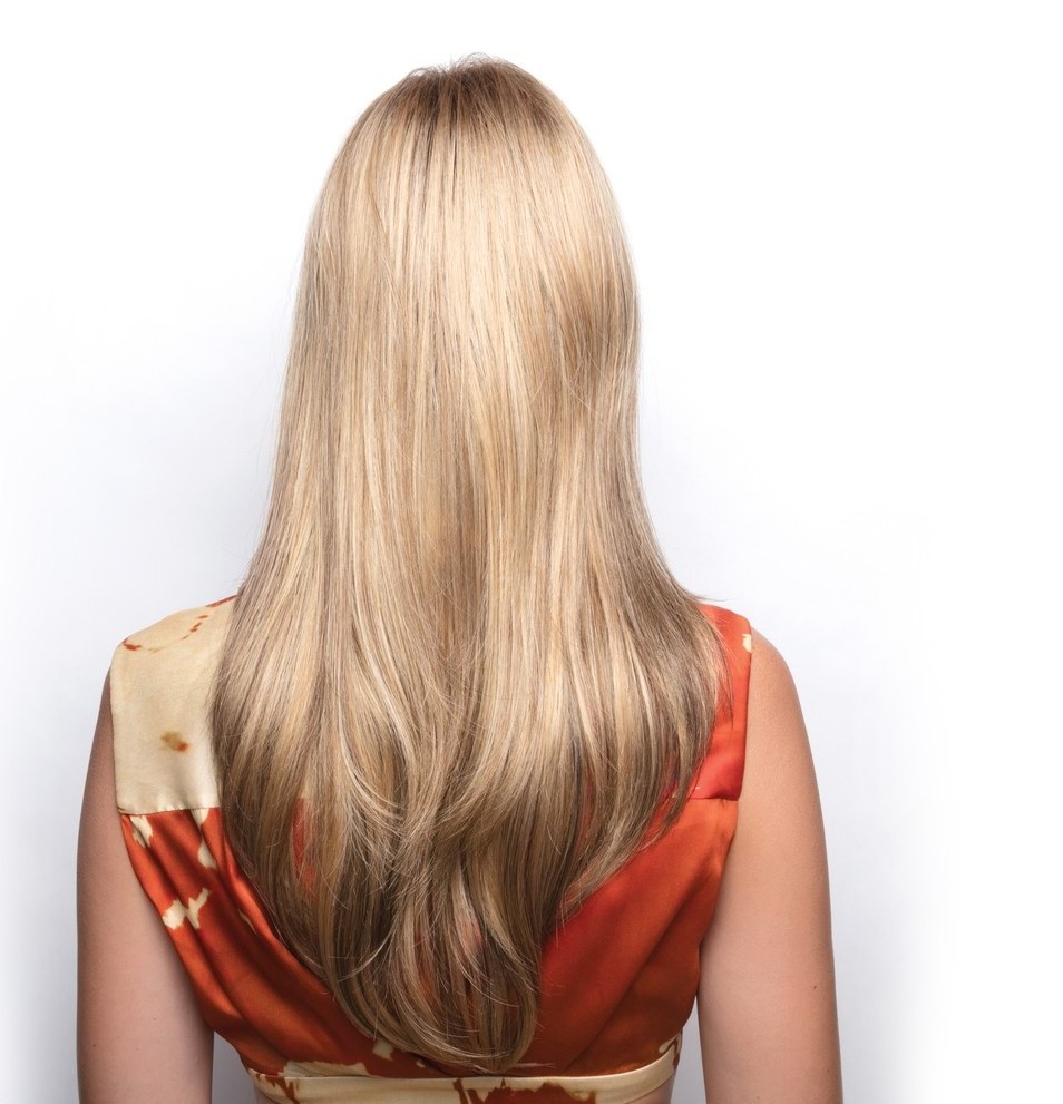 Back profile of woman wearing long and textured wig.