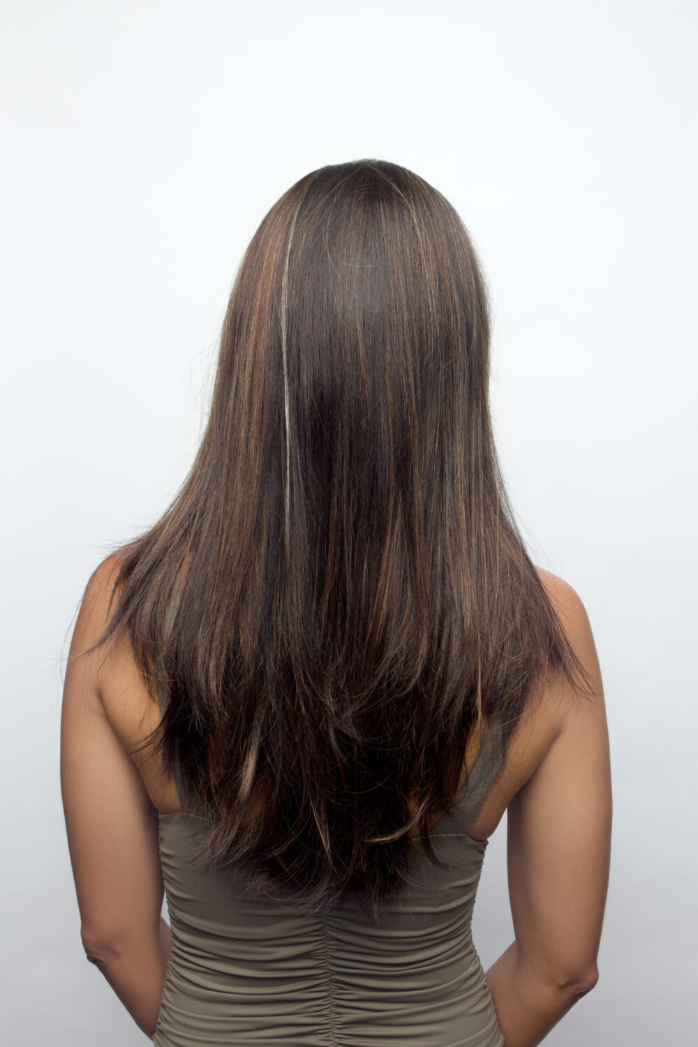 Back profile of woman wearing long and textured wig.